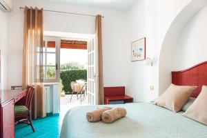 a bedroom with a bed with two towels on it at Poggio Aragosta Hotel & Spa in Ischia