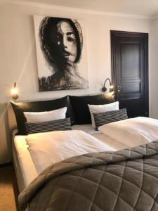 a bedroom with two beds and a painting on the wall at Park Hotel in Frederikshavn
