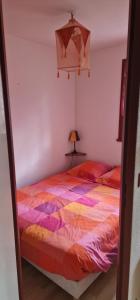 - une chambre avec un lit et une couette colorée dans l'établissement Appartement 4/6 le lioran, à Laveissière