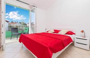 Habitación blanca con cama roja y balcón. en Apartments Ljubica Tivat en Tivat
