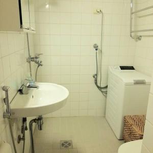 a white bathroom with a sink and a toilet at Urheilukatu20 Olympiastadion Ooppera, 4 makuupaikkaa in Helsinki