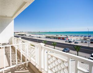 a balcony with a view of the beach and the ocean at Domus Hotel in Aktau