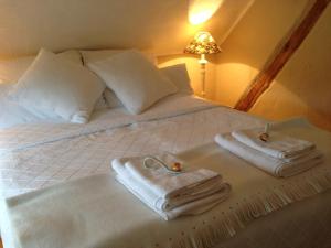 een wit bed met handdoeken erop bij All Seasons Bed & Breakfast in Kerpen