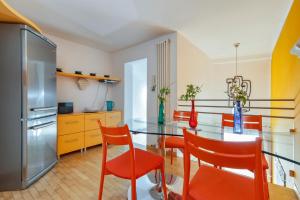 een keuken met een glazen tafel en oranje stoelen bij Porta Deuropa in Lecce