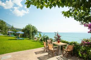 a patio with chairs and a table and the ocean at Rosa's Beach Studios in Lourdhata