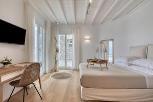 - une chambre blanche avec un lit et un bureau dans l'établissement Villa HADI, ideal for large groups and families, à Kalo Livadi