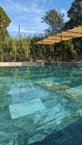 una gran piscina con dosel en el centro en Mas de la Roule, 4 studios, piscine chauffée, studio SPA, parc 2 ha, Pont d'Avignon à pied en Aviñón