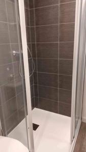 een douche met een glazen deur in de badkamer bij Appartement de l'EST N°2 in Montluçon