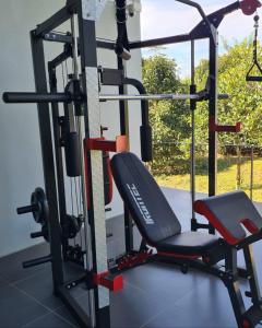 a gym with a bench and a chair at บ้านสวนภาคินรัตน์ 