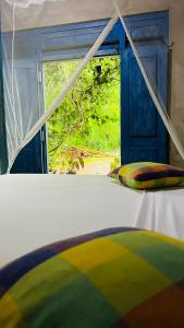 a bed in a room with a window at Kataragama Homestay in Kataragama