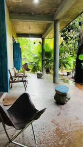 patio z krzesłem, stołem i ławką w obiekcie Kataragama Homestay w mieście Kataragama