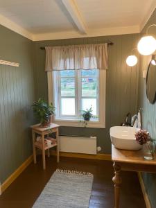 La salle de bains est pourvue d'un lavabo et d'une fenêtre. dans l'établissement Bårdstua, à Stokmarknes