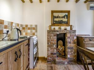 a kitchen with a brick fireplace with a picture on the wall at Shepherds Hut - Uk45529 in Buildwas