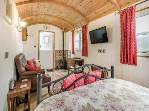 a bedroom with a bed and a tv in a room at Shepherds Hut - Uk45529 in Buildwas