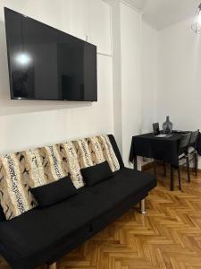 a living room with a couch with a television on the wall at El rincón exquisito in Albacete