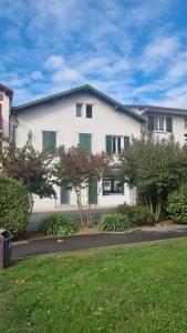a white house with green shutters on a street at Appartement T2 COSY HENDAYE CANETA in Hendaye