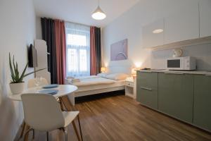 een kleine kamer met een keuken en een kleine tafel bij U Studanky CR Apartments in Praag
