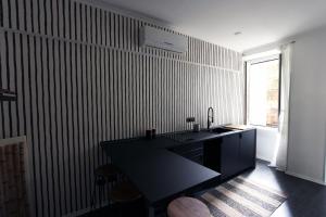 uma cozinha preta com um balcão preto e uma janela em Avignonesi Flat em Roma