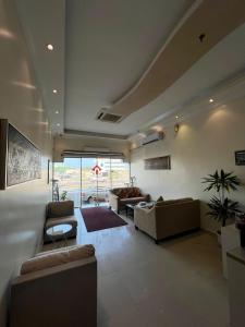 duży salon z kanapami i dywanem w obiekcie المواسم الاربعة للاجنحه الفندقية w mieście Al-Dżubajl