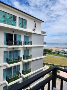 a building with balconies and the ocean in the background at LHC HOTEL AND RESORT in Pattaya