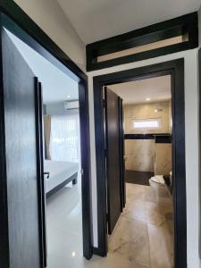 um quarto com uma porta e uma casa de banho com uma cama em LHC HOTEL AND RESORT em Pattaya Central