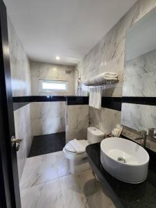 a bathroom with a white toilet and a sink at LHC HOTEL AND RESORT in Pattaya Central