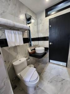 a bathroom with a white toilet and a sink at LHC HOTEL AND RESORT in Pattaya Central