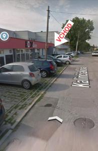 un estacionamiento con autos estacionados frente a una tienda en Ubytovanie FUNSTAR Topoľčany, en Topoľčany