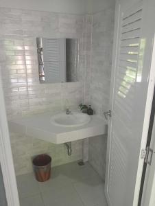 a white bathroom with a sink and a mirror at Scandinavian Beach Resort in Ko Lanta