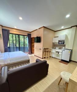 a bedroom with a bed and a couch and a kitchen at Kata Noi Place in Kata Beach