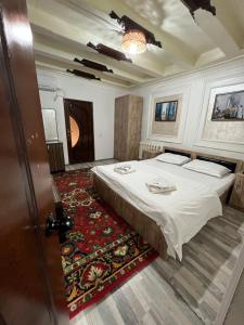 ein Hotelzimmer mit einem Bett und einem Teppich in der Unterkunft Zam-Zam Teracce in Buxoro