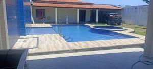 a swimming pool in a yard with a house at Casa de praia giovani in Aracaju