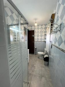 a bathroom with a glass shower and a toilet at Hostal Cabañeros in Ciudad Real