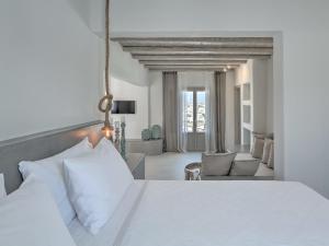 - une chambre avec un lit blanc et un salon dans l'établissement Hotel Papadakis, à Náoussa