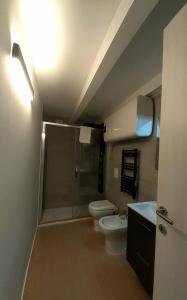 e bagno con doccia, servizi igienici e lavandino. di Piazza Teatro Apartments & Rooms a Trani
