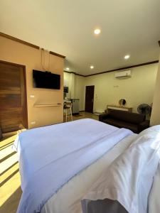ein Schlafzimmer mit einem großen weißen Bett und einem Sofa in der Unterkunft Kata Noi Place in Kata Beach