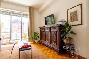 - un salon avec une grande armoire en bois et une fenêtre dans l'établissement Palazzo Lombardia - Central Station - BigHome, à Milan