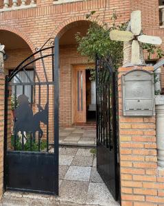 a black gate with a black dog on it at Hostal Cabañeros in Ciudad Real