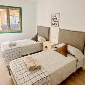 a room with two beds and a window at CozyCatalonia - Exclusive Attic in Central Blanes in Blanes