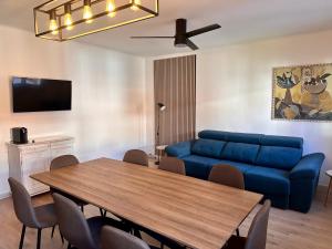 ein Wohnzimmer mit einem blauen Sofa und einem Tisch in der Unterkunft CozyCatalonia - Exclusive Attic in Central Blanes in Blanes