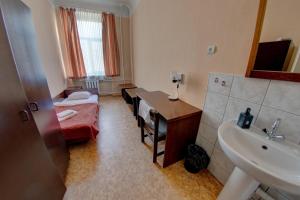 een badkamer met een kamer met een wastafel en een bed bij Hostel Viktorija with Private Rooms in Rīga
