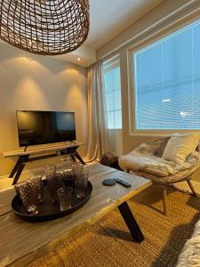 een woonkamer met een salontafel en een televisie bij Levistar311 in Sirkka