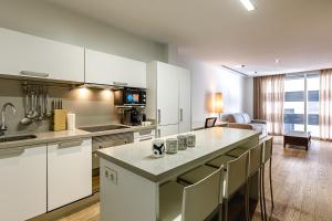 una cocina con armarios blancos y una isla de cocina en Cozy Apartment with AC en Elche