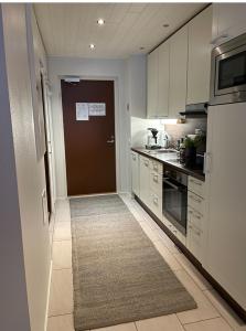 a kitchen with a brown door and a kitchen rug at Levistar311 in Sirkka