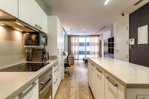 cocina con armarios blancos y encimera en Cozy Apartment with AC, en Elche