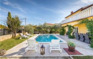 a backyard with a pool and chairs and a house at Awesome Home In Gajana With Wifi in Gajana