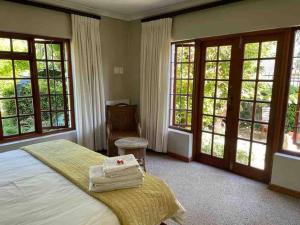 a bedroom with a bed with towels on it at Charming 2 Bed en-suite Cottage with Solar in Cape Town