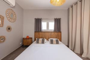 a bedroom with a large white bed and a window at Maisonnette à 400m de la Plage in Villeneuve-Loubet