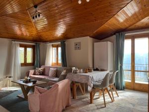 Chalet Arachova - Breathtaking View في أراخوفا: غرفة معيشة مع أريكة وطاولة