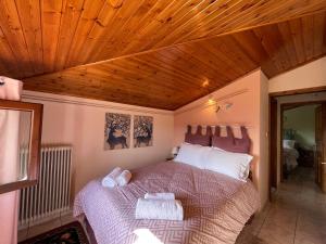 um quarto com uma cama e um tecto em madeira em Chalet Arachova - Breathtaking View em Arachova